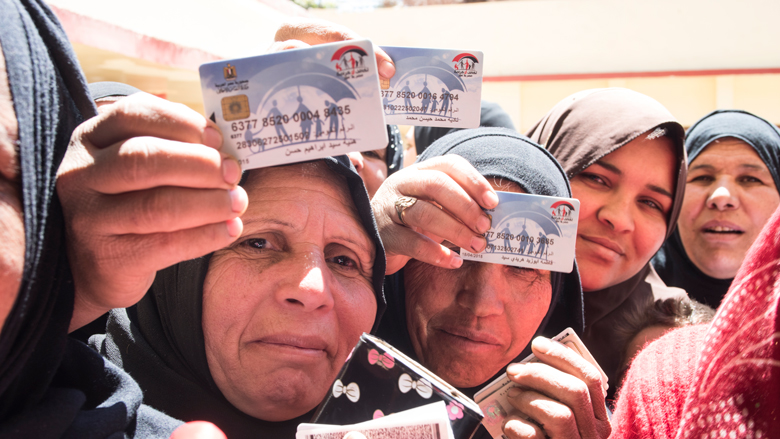 Four women, three holding up Takaful cards